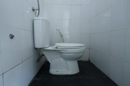 - une salle de bains avec des toilettes blanches dans une cabine dans l'établissement OYO 93130 Baloi Homestay, à Nagoya