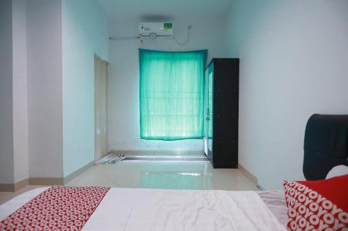 een slaapkamer met een bed en een bad met een raam bij OYO 93131 Mamapapahouse in Batam Center