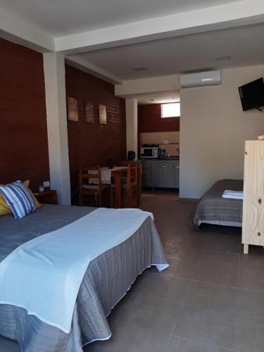 a bedroom with a bed and a kitchen with a table at Temporario Necochea 1 corrientes in Corrientes