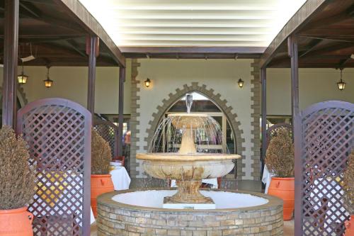a fountain in the middle of a room with plants at Makronisos Village in Ayia Napa