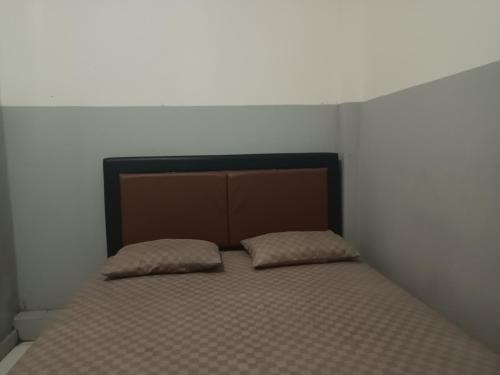a bed with two pillows on it in a bedroom at OYO 93090 Multi Plus Inn in Jayapura