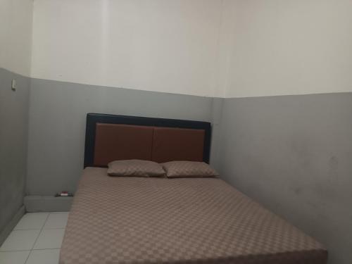 a bed in a white room with at OYO 93090 Multi Plus Inn in Jayapura