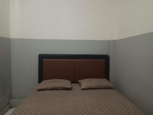 a bed with two pillows on it in a room at OYO 93090 Multi Plus Inn in Jayapura