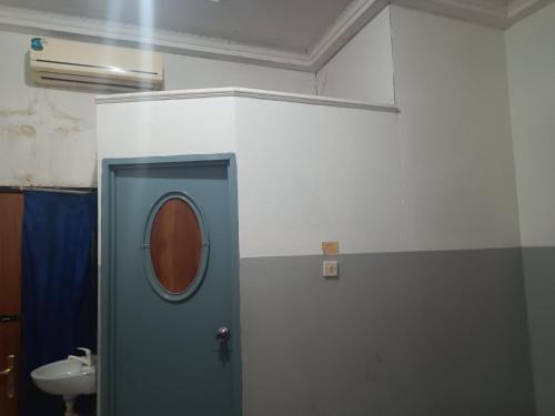 a bathroom with a blue door and a sink at OYO 93090 Multi Plus Inn in Jayapura