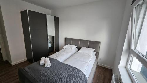 um quarto com 2 camas e lençóis brancos em APARTAMENT BUŁGARSKA 60m2-3 POKOJE-PIĘKNY WIDOK-13 PIĘTRO 24H CHECK IN em Poznań