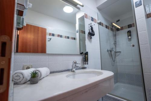 a bathroom with a sink and a shower at Hotel CityHome am Kurpark in Bad Salzuflen