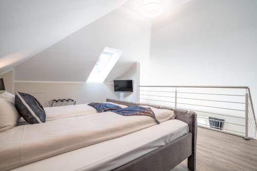 a bedroom with two beds and a tv on the wall at Hotel CityHome am Kurpark in Bad Salzuflen