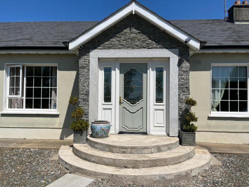 uma casa com uma porta branca e escadas em The Gables 