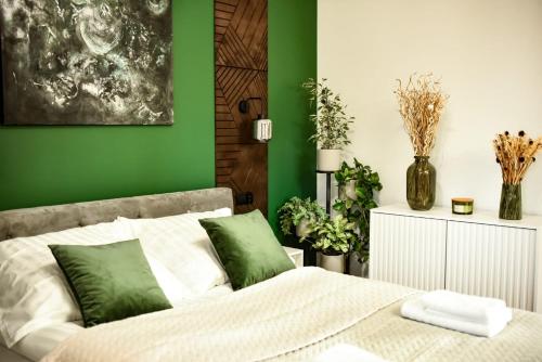 a green bedroom with a bed with green walls at Benefis Tatarska in Przemyśl