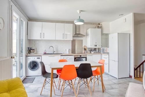 una cocina con mesa y sillas naranjas. en Spacieux Havre Chic à Angoulême, en Angulema