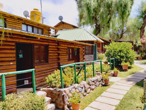 una cabaña de madera con una pasarela delante de ella en Cabañas Pacari Tampu en Mendoza