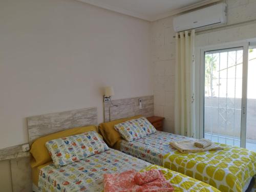 a bedroom with two beds and a window at Casa Macarena 07 in Ciudad Quesada