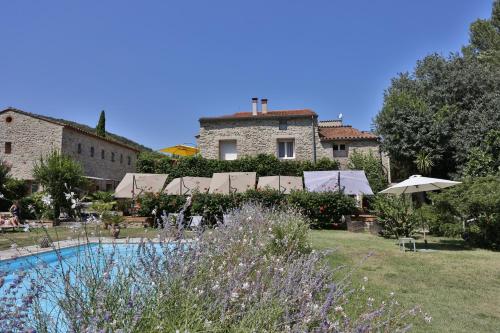 a resort with a swimming pool in front of a building at Hotel Le Mas Trilles in Céret