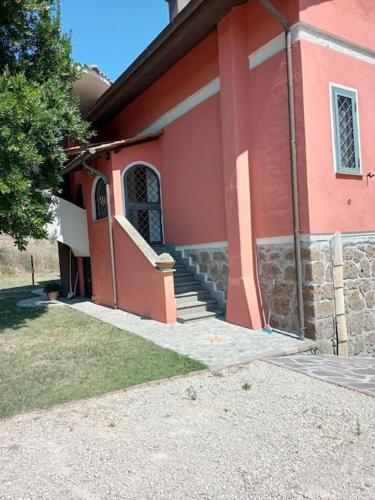 a red house with stairs in front of it at Campo del Gatto in Viterbo