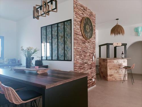 una cucina con bancone e muro di mattoni di Maison neuve 200m2 climatisée, proche de la plage et des commerces ad Audenge
