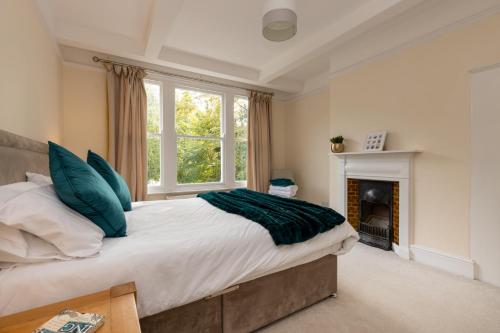 a bedroom with a large bed and a fireplace at The Limes in Harston