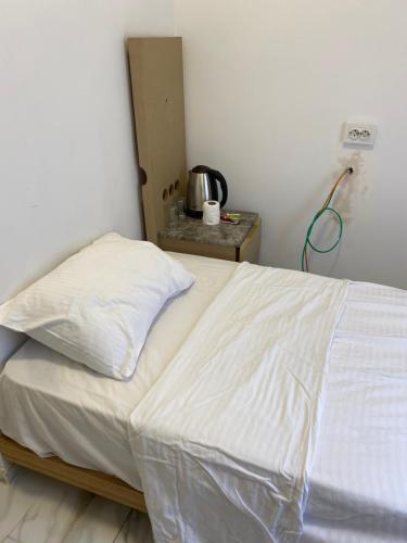 1 dormitorio con 1 cama con sábanas blancas y mesa en yenikap hotel, en Estambul