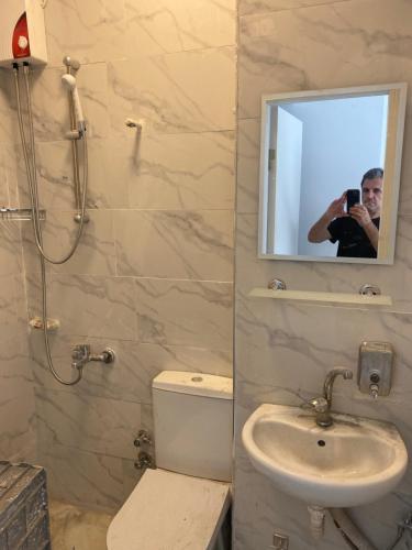 a man taking a picture of a bathroom with a mirror at yenikap hotel in Istanbul