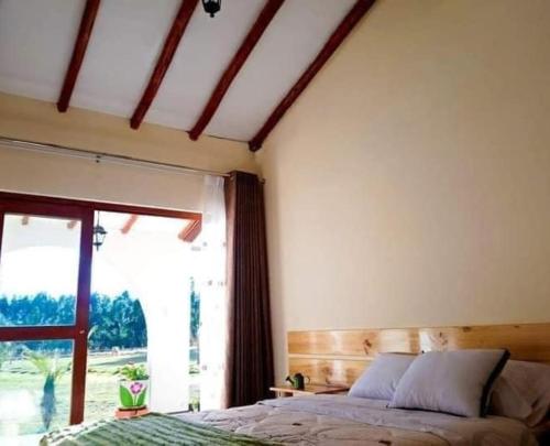 een slaapkamer met een bed en een groot raam bij Fundo Alma Andina in Jauja