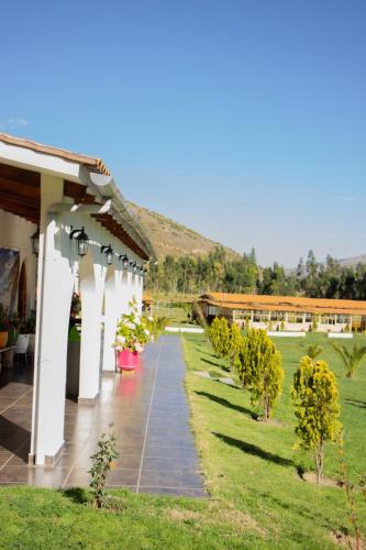 a walkway next to a building with a row of trees at Fundo Alma Andina in Jauja