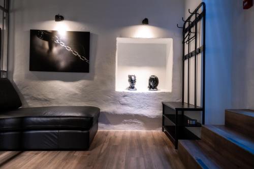 uma sala de estar com um sofá de couro preto e duas esculturas em BDSM Black Apartments em Vilnius