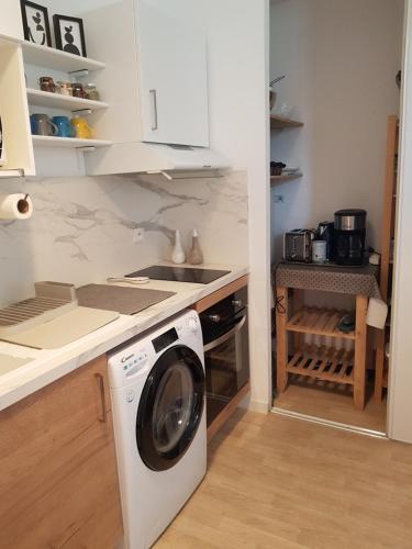 une cuisine avec une machine à laver dans une cuisine dans l'établissement Appt plein coeur de Soulac sur Mer, à Soulac-sur-Mer