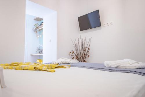 a bedroom with a bed with a tv on the wall at Little gem by the sea in Chania