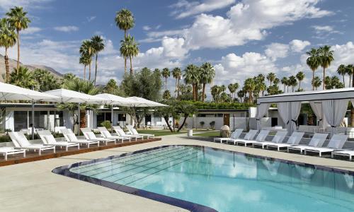 a patio area with chairs, tables, and umbrellas at L'Horizon Resort & Spa in Palm Springs