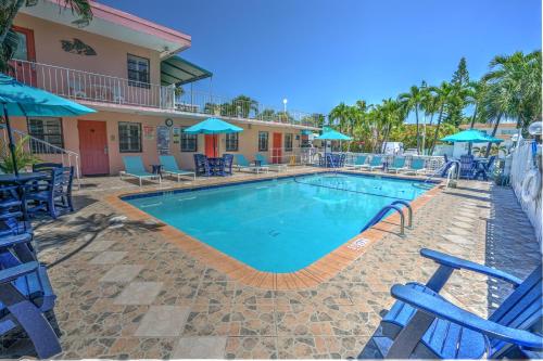 una piscina in un resort con sedie blu e ombrelloni di Sea Garden by the Sea a Fort Lauderdale