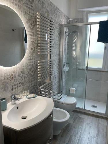 ein Badezimmer mit einem Waschbecken, einem WC und einem Spiegel in der Unterkunft Da Francesco in Pisa