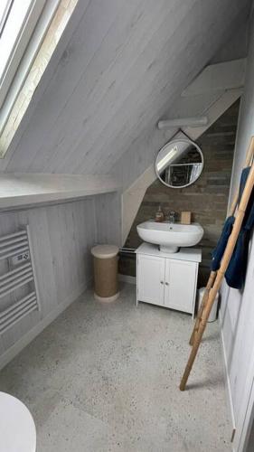 une petite salle de bain avec un lavabo et un miroir dans l'établissement Maison vue mer Omaha Beach, à Vierville-sur-Mer
