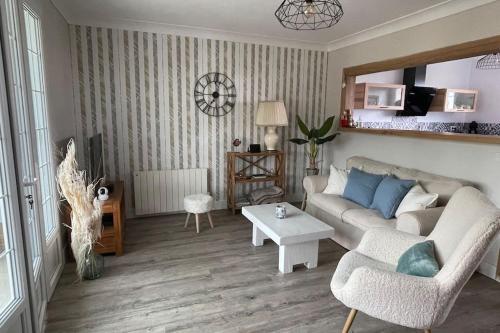 a living room with a couch and a table at Maison vue mer Omaha Beach in Vierville-sur-Mer