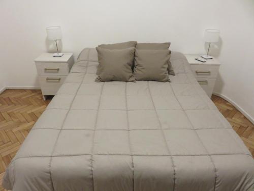 a large bed in a room with two night stands at Oasis Palermo Soho in Buenos Aires