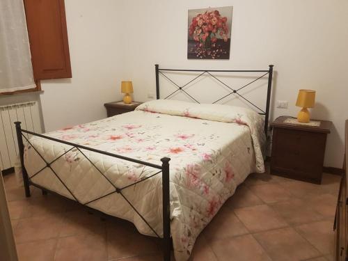 ein Schlafzimmer mit einem Bett und zwei Nachttischen mit Lampen in der Unterkunft Casa Imola in Poggibonsi