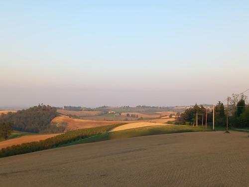 a view of a field with a road and trees at IL CORTILE DI GRETA in Lu