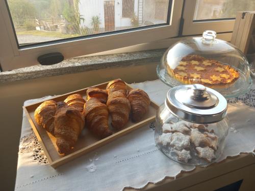 una mesa con una bandeja de cruasanes y un pastel en IL CORTILE DI GRETA en Lu