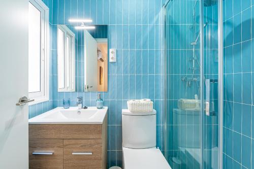 ein blau gefliestes Bad mit WC und Waschbecken in der Unterkunft El balcón de los pintores in Málaga