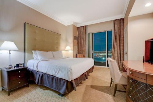 um quarto de hotel com uma cama, uma secretária e uma televisão em MGM Signature Tower 3 w/extended balcony em Las Vegas