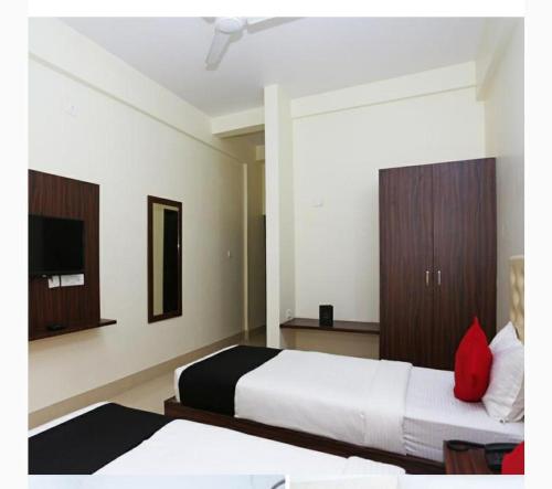 a hotel room with two beds and a tv at Triple Tree Hotel & Resorts in Bhubaneshwar