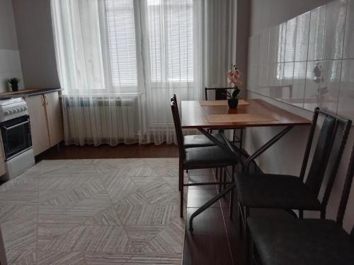 a kitchen with a table and chairs in a room at Квартира in Aktobe