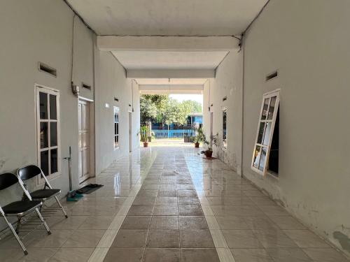 un couloir vide d'un bâtiment avec des chaises dans l'établissement OYO 93137 Kost Maharaja, à Makassar