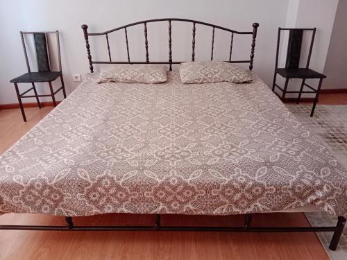 a bed in a room with two chairs at Квартира in Aktobe