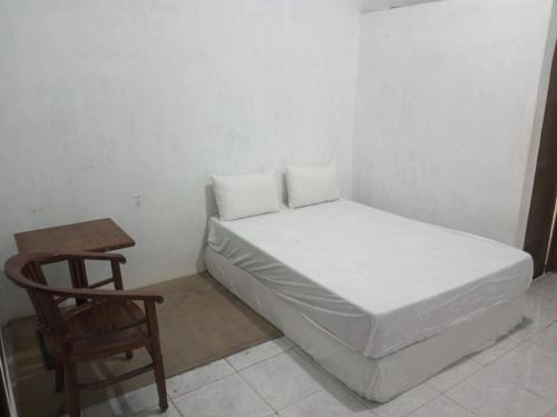 a bed in a room with a table and a chair at OYO 93161 Nurul Hikmah Homestay Syariah & Sport Center in Sedati