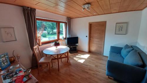 a living room with a blue couch and a table at Kalberkamp Ferienwohnung in Kierspe