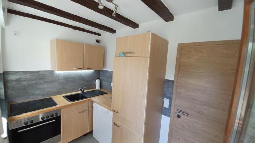 eine kleine Küche mit Holzschränken und einem Waschbecken in der Unterkunft Kalberkamp Ferienwohnung in Kierspe