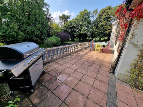 a grill and a patio with a table and chairs at Gap Retreat in Carrickmore