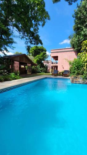 une grande piscine en face d'un bâtiment dans l'établissement Rincón Escondido B&B, à Puerto Iguazú