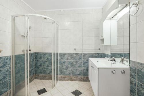y baño con ducha y lavamanos. en Mountain & Sea View Apartment Tromsø, en Tromsø