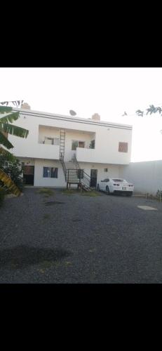 a white building with a car parked in front of it at Departamento en Tonalá in Guadalajara