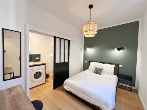 - une chambre avec un lit blanc et un lave-linge dans l'établissement LE TREFLE DE FALGUIERE - Hypercentre- Gare, à Toulouse